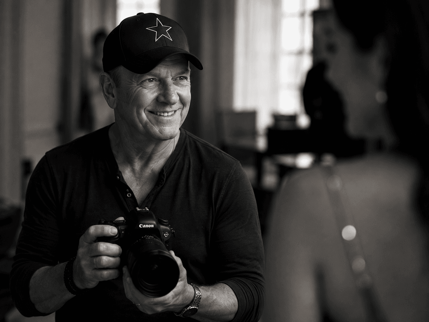 Tim Bennett smiling while holding his camera during a portrait session